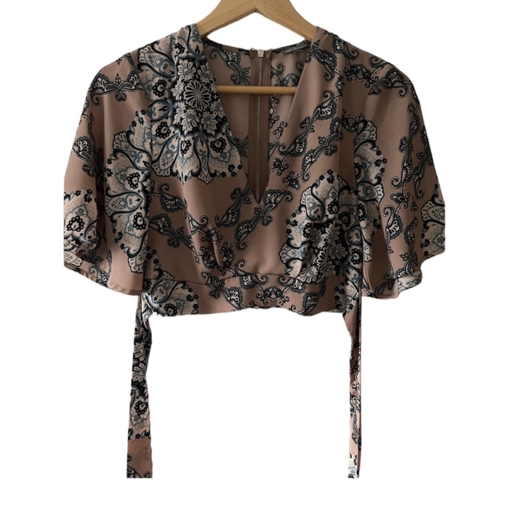 Cropped flowered blouse with tie and zipper. Plunging neckline bell sleeves